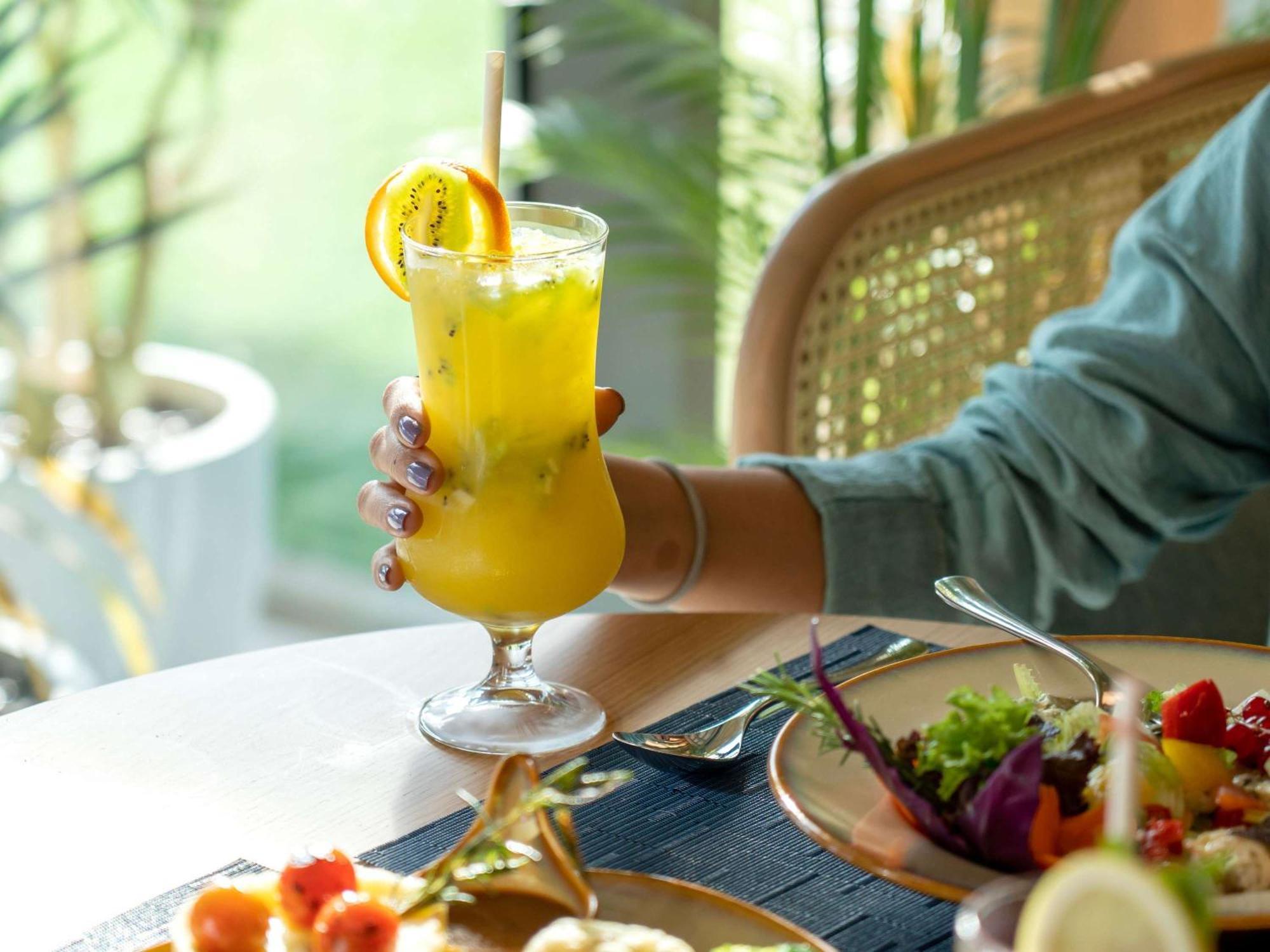Swissotel Living Jeddah Ngoại thất bức ảnh A woman holding a glass of juice